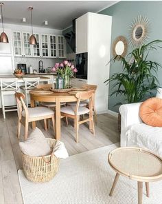 a living room filled with furniture next to a kitchen and dining room table in front of a window