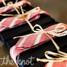 four black and red boxes tied with twine on top of each other, sitting on a table