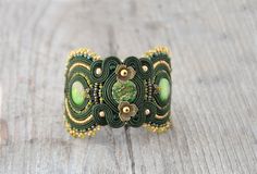 Green soutache bracelet with jasper stones, khaki bracelet, embroidered bracelet, beaded bracelet, embroidered cuff, soutache jewelry, nature bracelet. Jasper stones in your bracelet may look a bit different, because all stones are unique. Made with love and big care, includes many many hours of work and non sleeping nights:) Widest pats is 4,7cm. (1,85 inches), in the center 3,5cm. (1,37 inches) Embroidered and glued. Adjustable size. Important: in reality colors may be slightly different, depe Hand Embroidered Jewelry, Soutache Bracelet, Embroidered Bracelet, Soutache Necklace, Jewelry Nature, Soutache Earrings, Soutache Jewelry, Colorful Jewelry, Bracelet Beaded