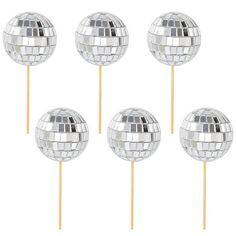 four silver disco ball lollipops sitting on top of each other