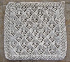 a white crocheted dishcloth sitting on top of a tile floor