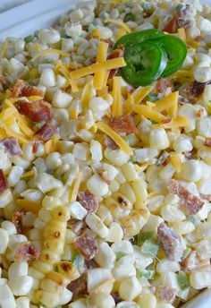 corn salad with bacon and cheese in a white bowl