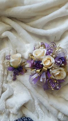 two bridal bouquets on a white blanket with purple and gold flowers in the center