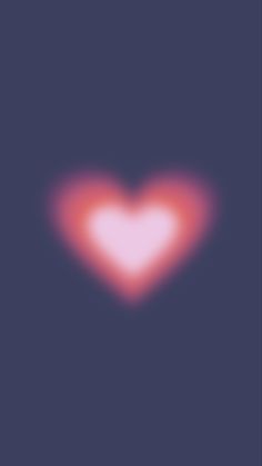 a blurry image of a red heart on a dark blue background with pink highlights