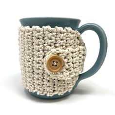 a crocheted coffee cup with a button on the front and bottom is shown