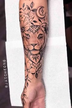 a person with a tattoo on their arm is holding a flower and a lion's head