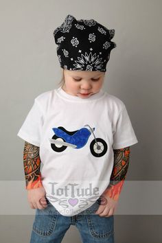 a small child wearing a t - shirt with a motorcycle on it's chest