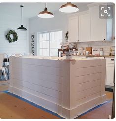 a kitchen with white cabinets and an island