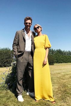 a man and woman standing next to each other in a field