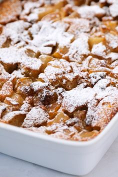 a close up of a cake in a pan with powdered sugar on top