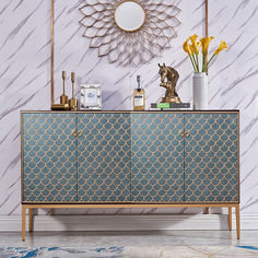 a blue and gold sideboard with vases on it next to a wall mounted mirror