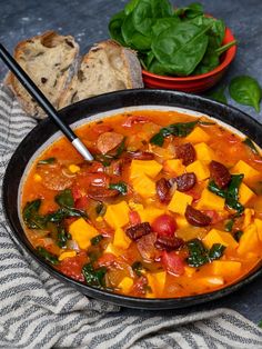 a bowl of vegetable soup with bread and spinach