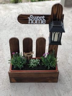 a small wooden planter with plants in it and a sign that says sweet home