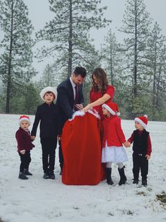 a family dressed up for christmas standing in the snow