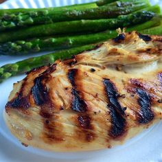 a white plate topped with chicken and asparagus