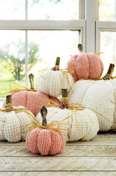 knitted pumpkins sitting on top of each other in front of a windowsill