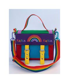 A lovely handmade rainbow canvas satchel handbag for kids (and grown ups!) with adjustable, removable straps that can be personalised. Completely multicoloured, with a blue canvas pocket at the front on red canvas with purple sides and a dark blue back, with the top being green and the lining is yellow. The strap and handle are rainbow webbing, and the buckles are silver. The bag has soft foam to reinforce the sides. THIS IS A SMALL SATCHEL HANDBAG, PLEASE READ CAREFULLY THE DIMENSIONS OF THE BA Playful Satchel Shoulder Bag For School, Playful Shoulder Bag With Adjustable Strap For School, Cute School Satchel Crossbody, Fun Satchel Shoulder Bag For School, Playful Satchel Bag For School, Back To School Crossbody Satchel For School, School Satchel Crossbody For Back To School, Cute Multicolor School Satchel, Rectangular Multicolor Satchel For School