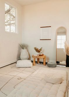 a room with a bed, mirror and other items on the floor in front of it