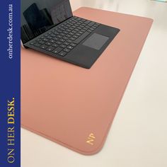 an open laptop computer sitting on top of a pink surface