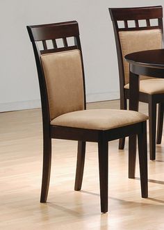 a dining room table with four chairs and one chair upholstered in beige fabric