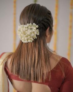 the back of a woman's head wearing a hair comb with flowers in it