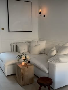 a living room with a white couch and ottoman