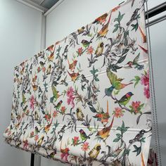 a curtain with birds and flowers on it hanging from the side of a wall in an office building