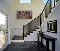 an entry way with stairs and black tile flooring