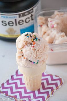 a scoop of ice cream with sprinkles on top and a container in the background