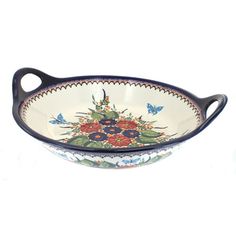 a blue and white bowl with flowers on the bottom, sitting in front of a white background