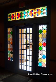 an open door with stained glass on the front and side windows that have different colored circles in them