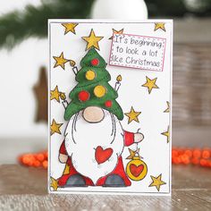 a handmade christmas card with a santa clause holding a tree and saying it's beginning to look a lot like christmas