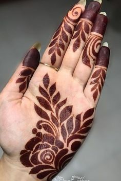 a woman's hand with henna tattoos on it