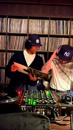 two young men are playing music in front of a record player