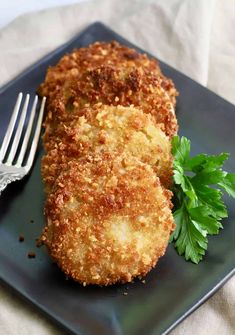 fried green tomatoes on a blue plate with a fork and parsley garnish