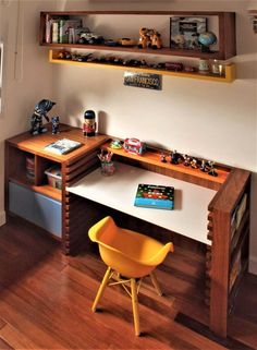 there is a desk with shelves above it and a yellow chair in front of it