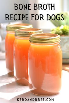 three jars filled with orange liquid sitting on top of a table