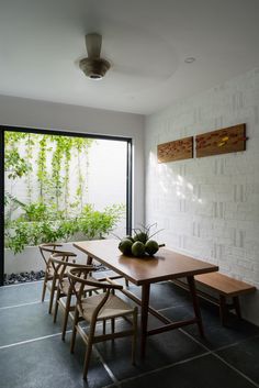 a dining room table with chairs and fruit on it in front of a sliding glass door