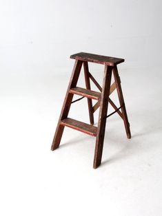 a wooden step stool sitting on top of a white floor