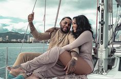 a man and woman sitting on the back of a boat