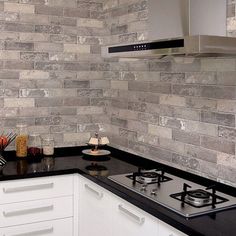 a kitchen with white cabinets and black counter tops is pictured in this image, there are two burners on the stove