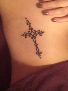 a woman's stomach with a cross tattoo on it