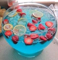 a blue bowl filled with fruit and ice