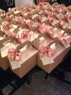 several boxes with pink bows on them sitting on a table