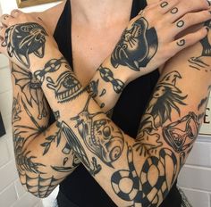 a woman with many tattoos on her arms and hands, both holding their hands together