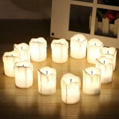 many lit candles sitting on top of a wooden table next to a white microwave oven