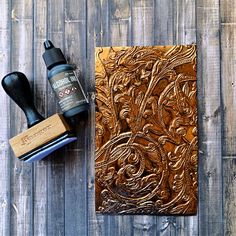 a wooden block with a rubber stamp next to it and some ink on the board