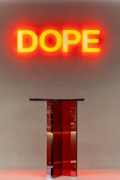 a sign that says dope on the side of a wall next to a table