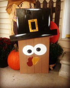 a cardboard turkey with a hat on it's head sitting in front of a house