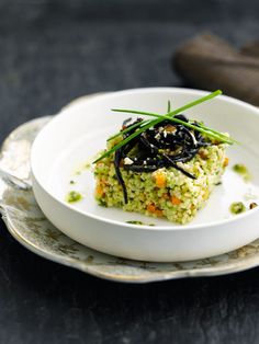 a white plate topped with food on top of a black table next to a fork